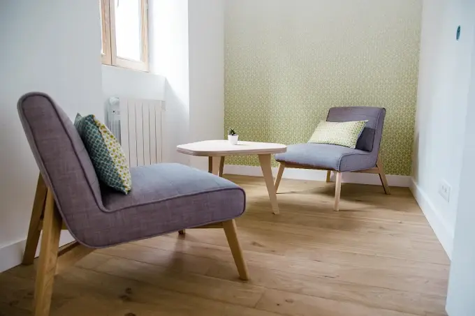 Bureau vert, petit bureau avec une fenêtre, une petite table et deux sièges confortables face à face.