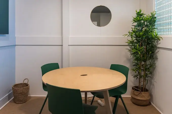 Boudoir, petite pièces avec petite table ronde et trois chaises, petit miroir rond au mur et plante dans le coin. Moquette au sol.