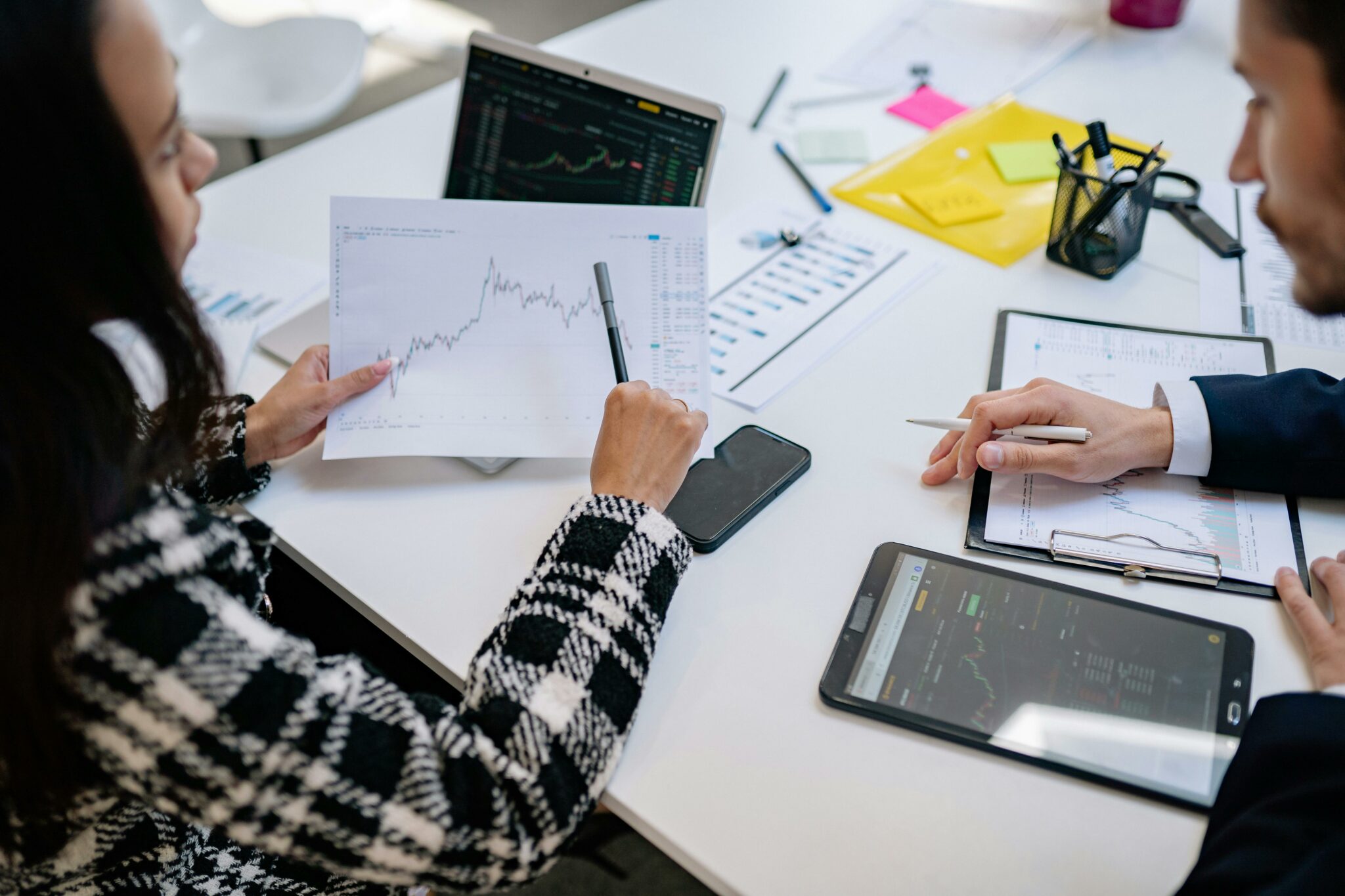groupe de personnes travaillant autour d'une table, sur feuilles et ordinateur